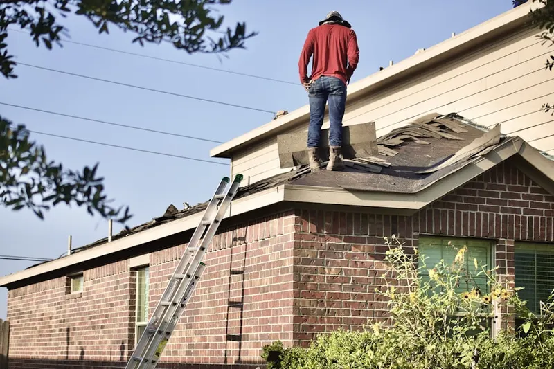Professional roofer working on a residential roof in Imler